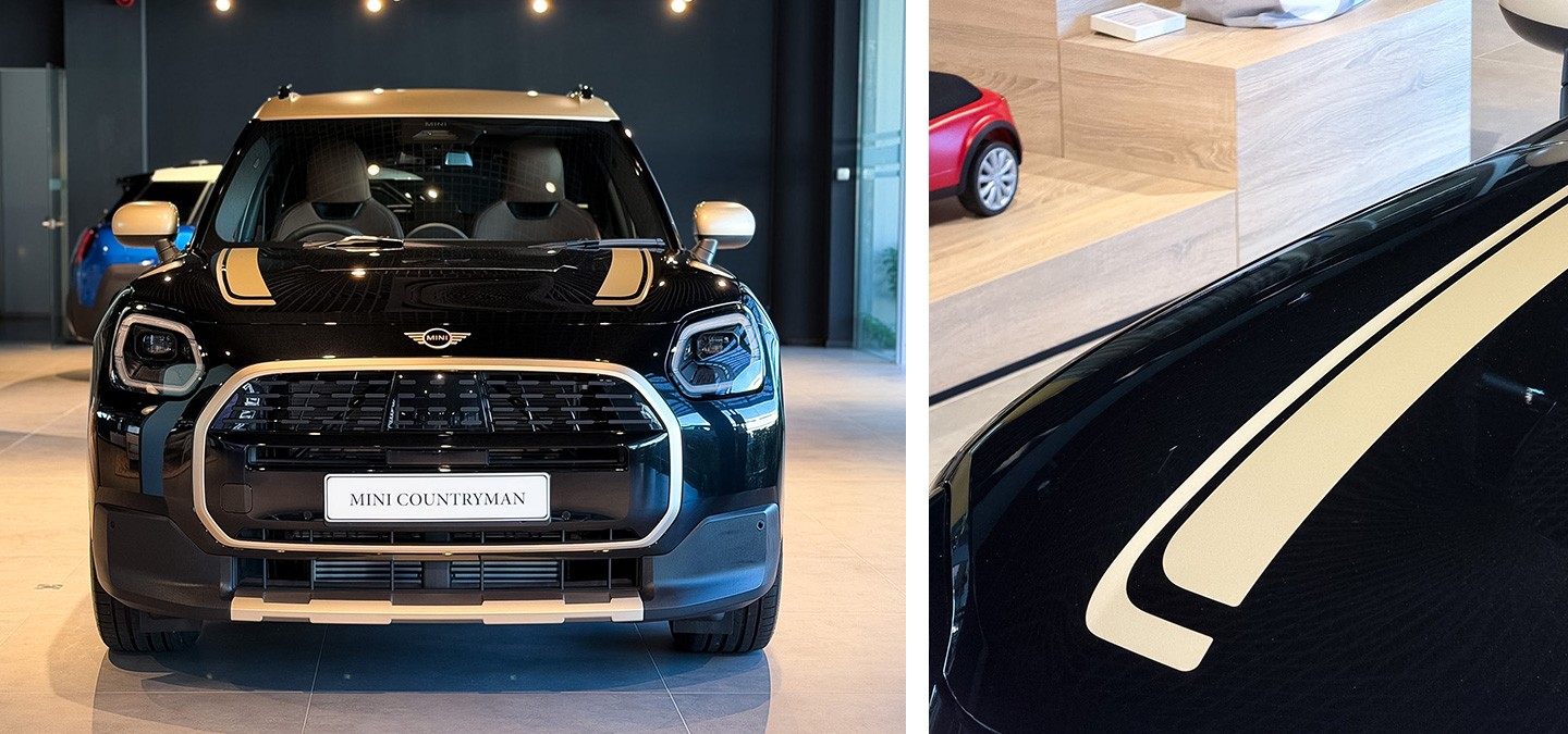 Front view of the MINI Countryman JCW in Legend Grey and Red Roof and the MINI Countryman in Smokey Green and Vibrant Silver Roof standing next to each other.
